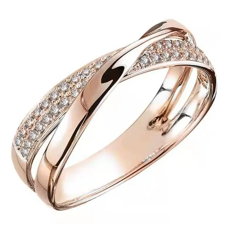Anel feminino cruzado em prata com banho rosé e zircônias brilhantes cravejadas. Perfeito para mulheres que buscam um acessório luxuoso, moderno e cheio de charme para ocasiões especiais.