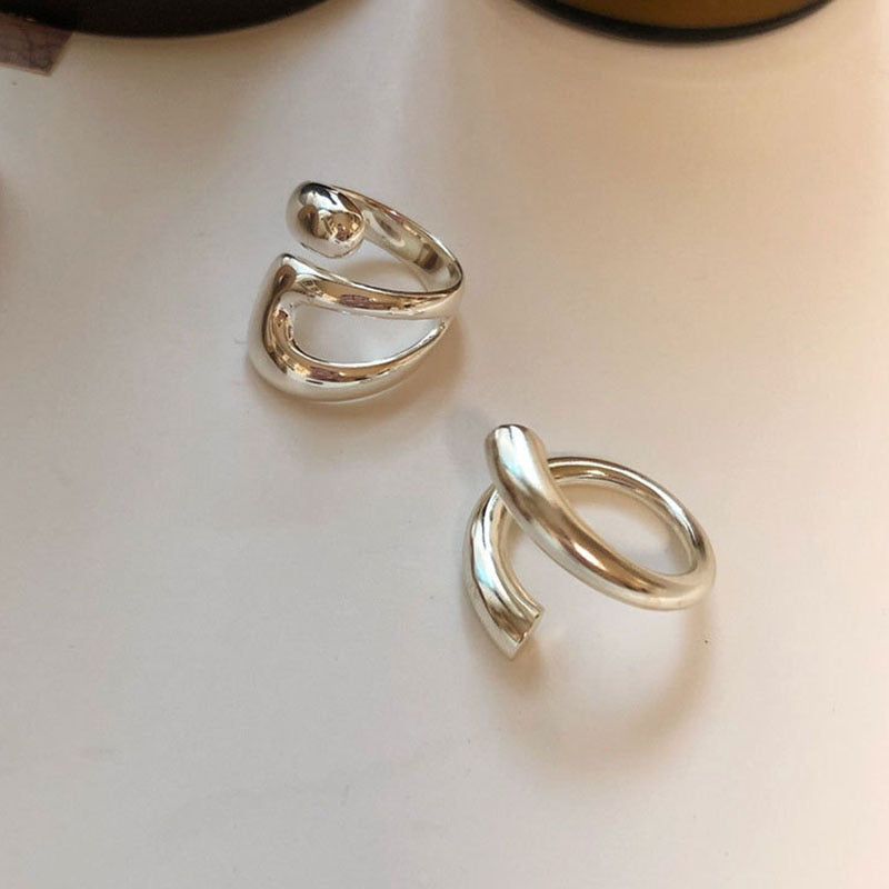 nel feminino cruzado em prata com design moderno e acabamento brilhante. Ideal para quem deseja um acessório elegante, versátil e sofisticado para o uso diário ou ocasiões especiais.