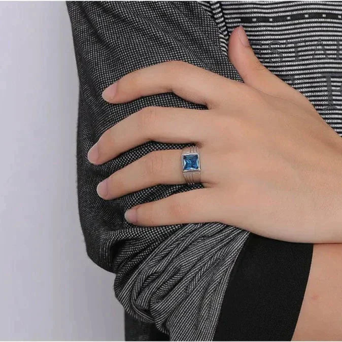 Anel masculino prata com pedra zircão azul de brilho intenso. Um acessório sofisticado e contemporâneo, ideal para elevar produções sociais ou casuais com elegância.