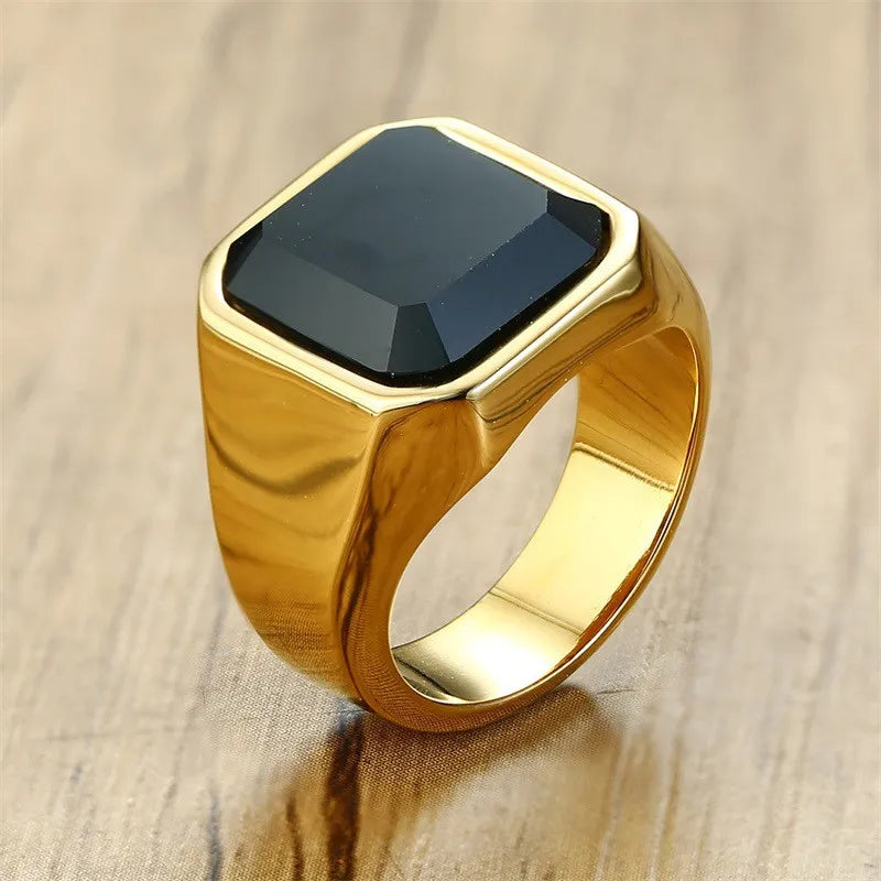 Anel masculino dourado com pedra ônix preta e acabamento polido. Ideal para compor looks elegantes com um toque de sofisticação e personalidade marcante.