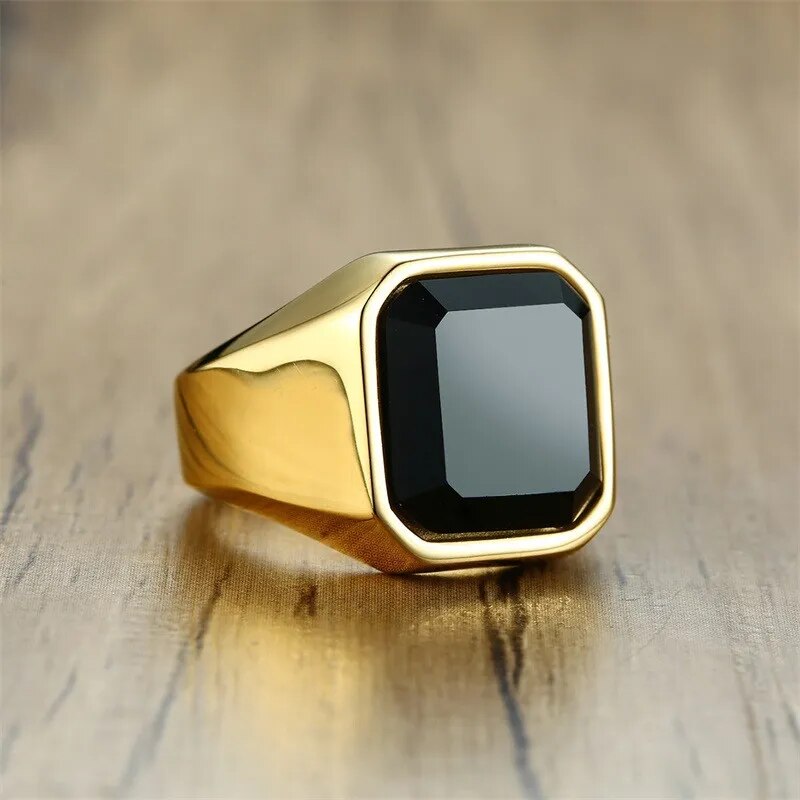 Anel masculino dourado com pedra ônix preta e acabamento polido. Ideal para compor looks elegantes com um toque de sofisticação e personalidade marcante.