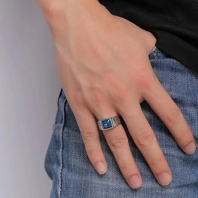 Anel masculino prata com pedra zircão azul de brilho intenso. Um acessório sofisticado e contemporâneo, ideal para elevar produções sociais ou casuais com elegância.