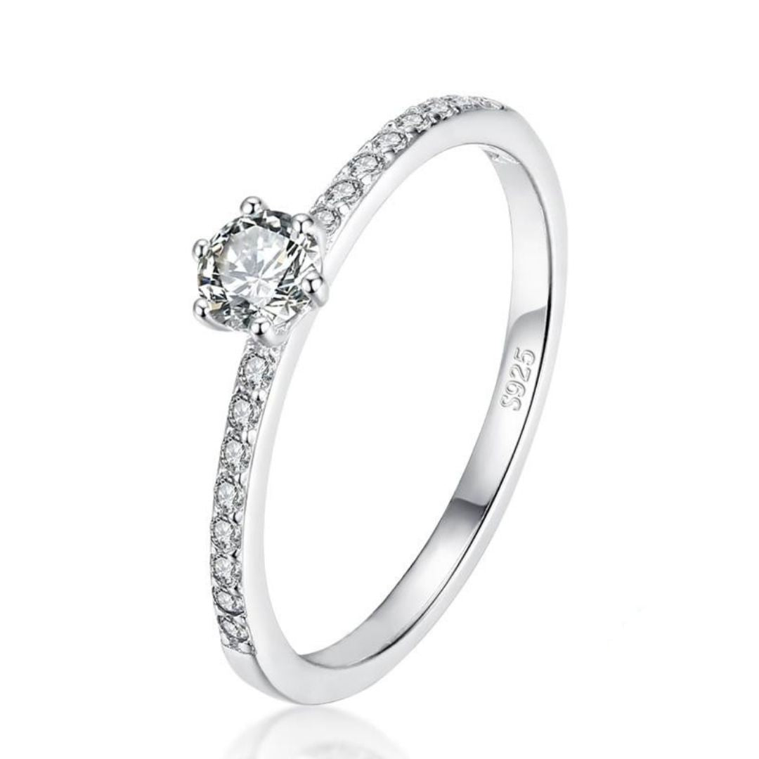 Anel solitário feminino em prata com pedra central cravejada e detalhes delicados. Uma joia atemporal, perfeita para noivado ou para compor produções clássicas e românticas.